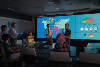 Team discussing global PCI DSS compliance strategy with interactive map