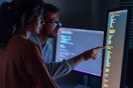 People looking at a code on computer screen