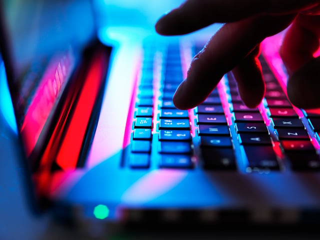 Keyboard close-up with fingers about to press a key
